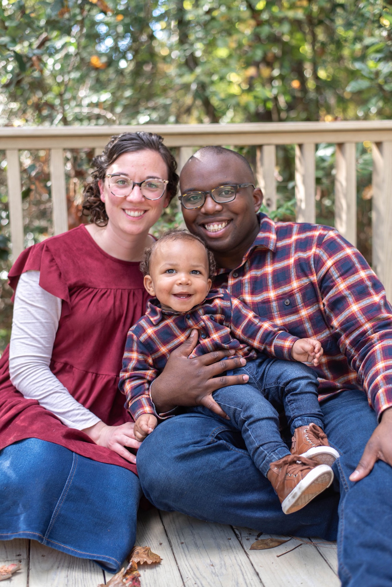 A man and woman sitting on a porch with a baby